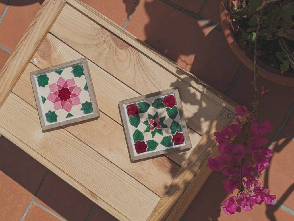 Dos posavasos Florals sobre una mesa de madera al aire libre con buganvilla